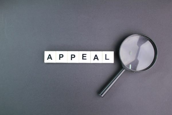 magnifying glass over appeal scrabble letters